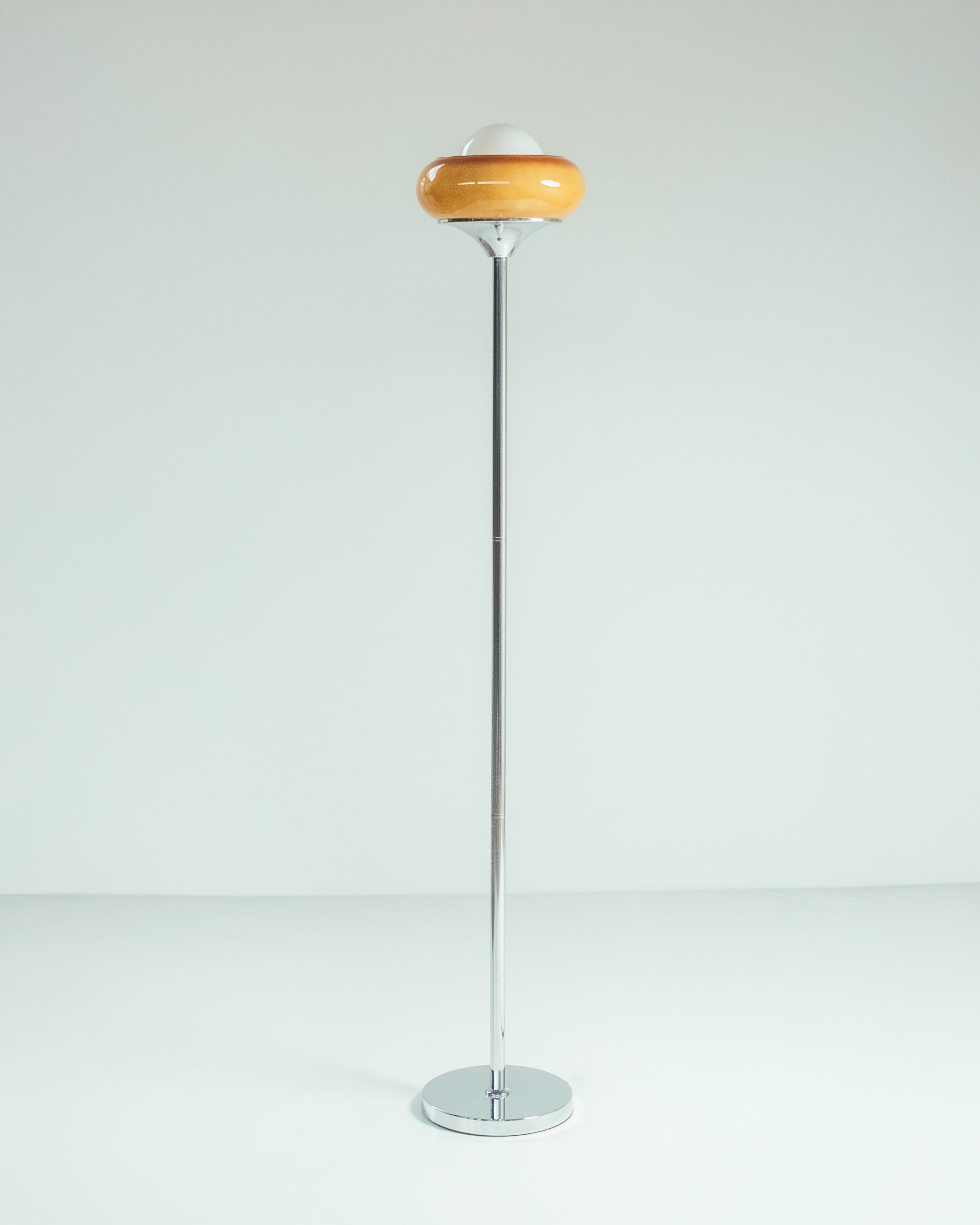 Retro lamp with an amber shade and white globe, styled on a side table with books, adding vintage charm to modern decor.