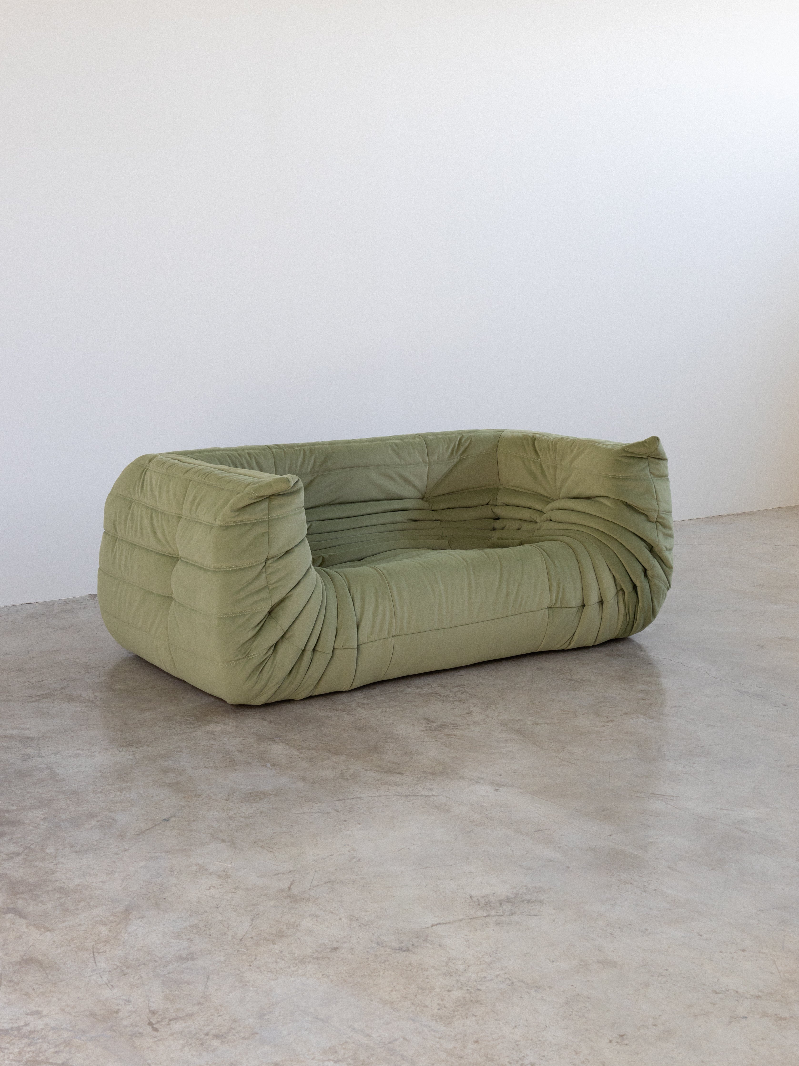 Light green modular two-seater sofa with unique wrinkled design.