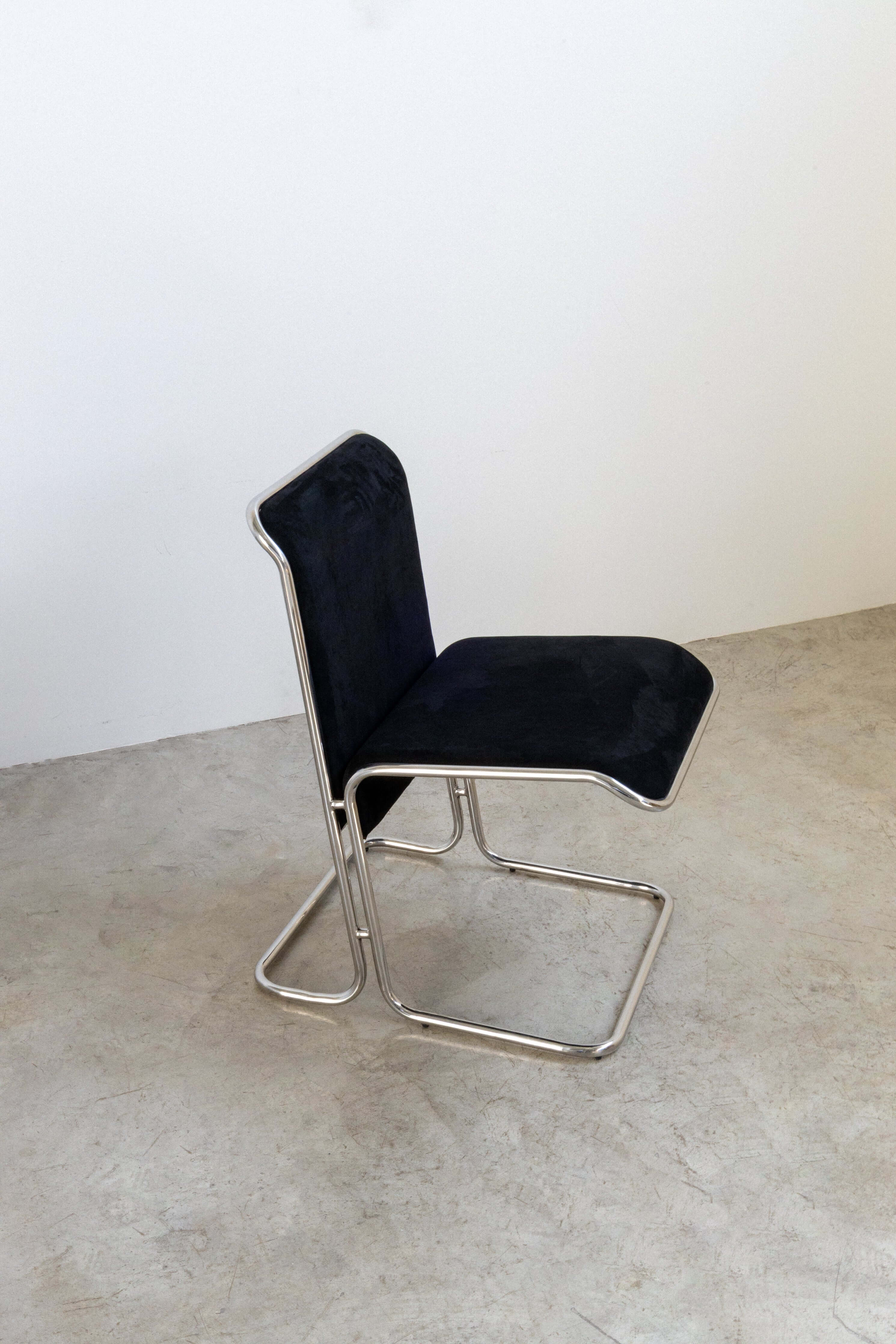 Calla Chair - Black chair with metal frame on a concrete floor
