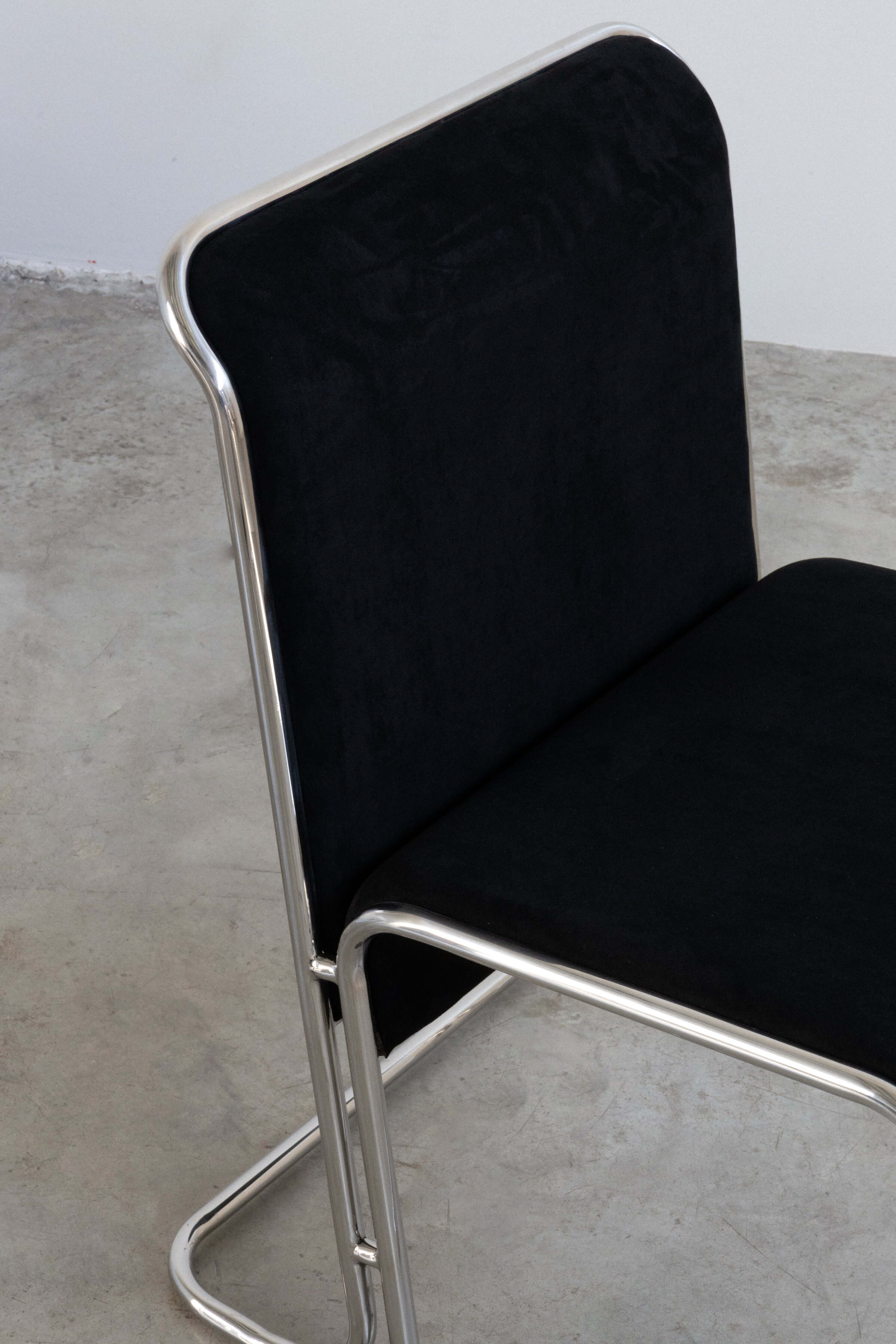 Calla Chair - Black chair with metal frame on a concrete floor