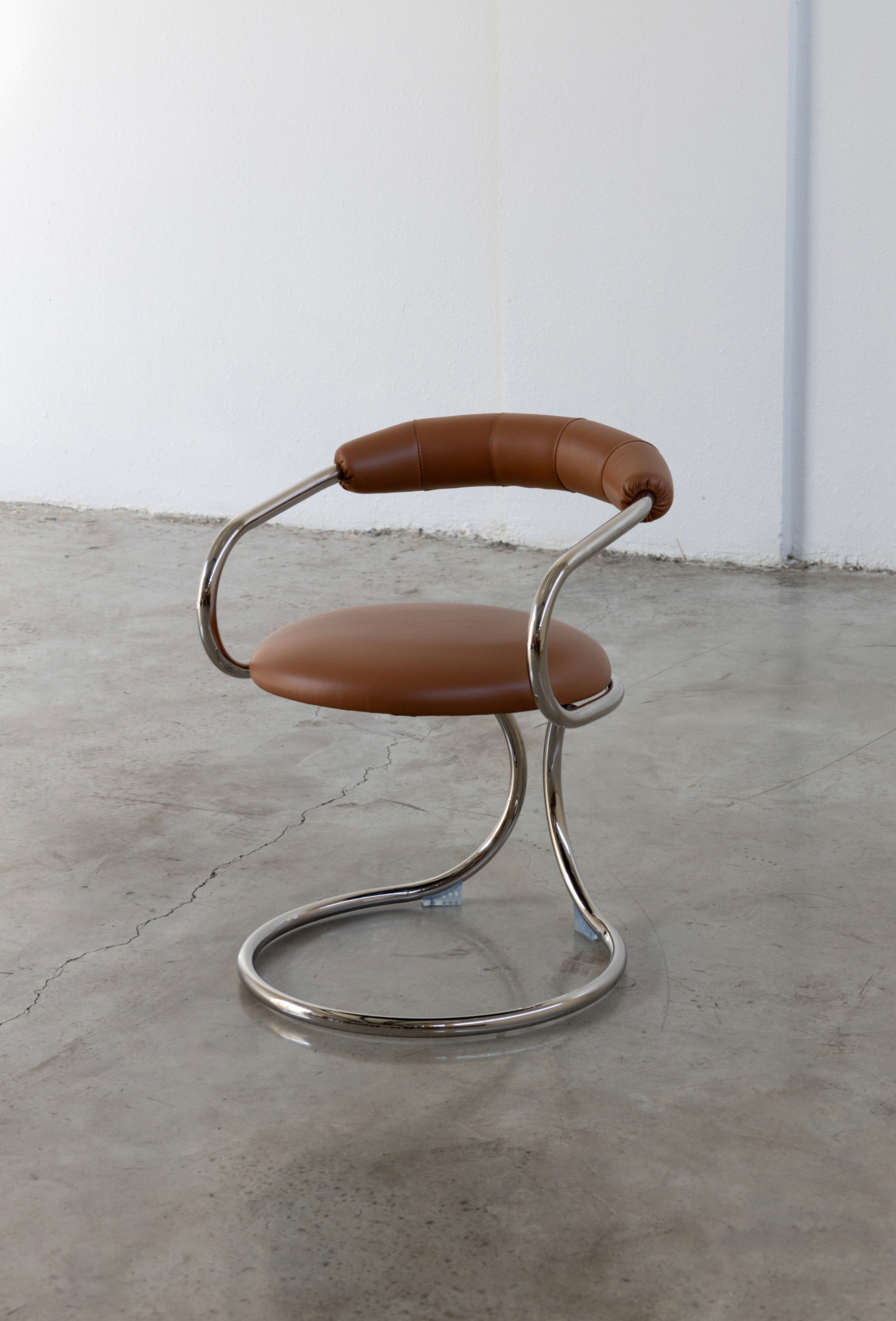 A modern upholstered chair with a black seat and backrest, and a chrome-plated metal frame.