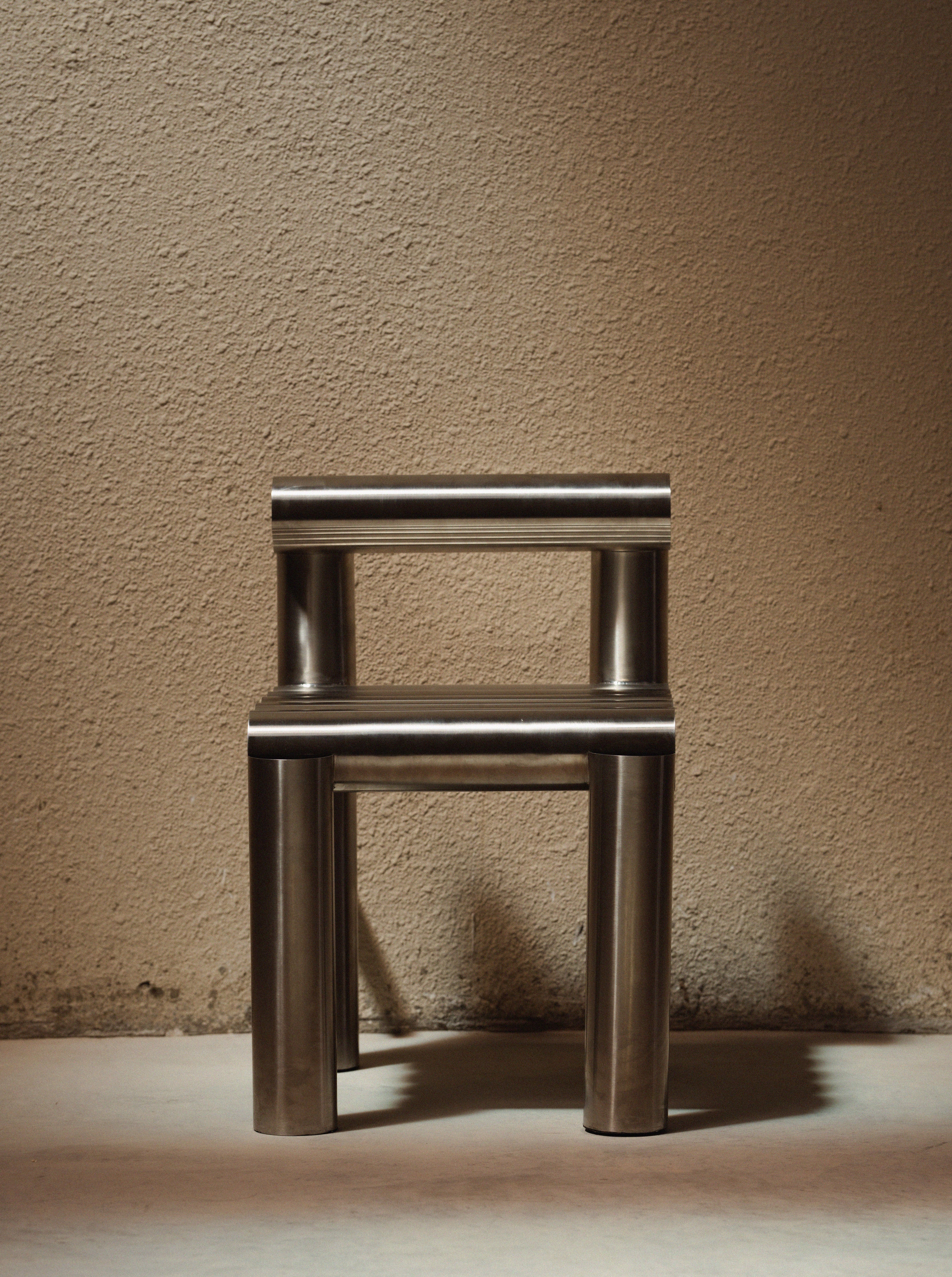 Metallic chair against a textured beige wall
