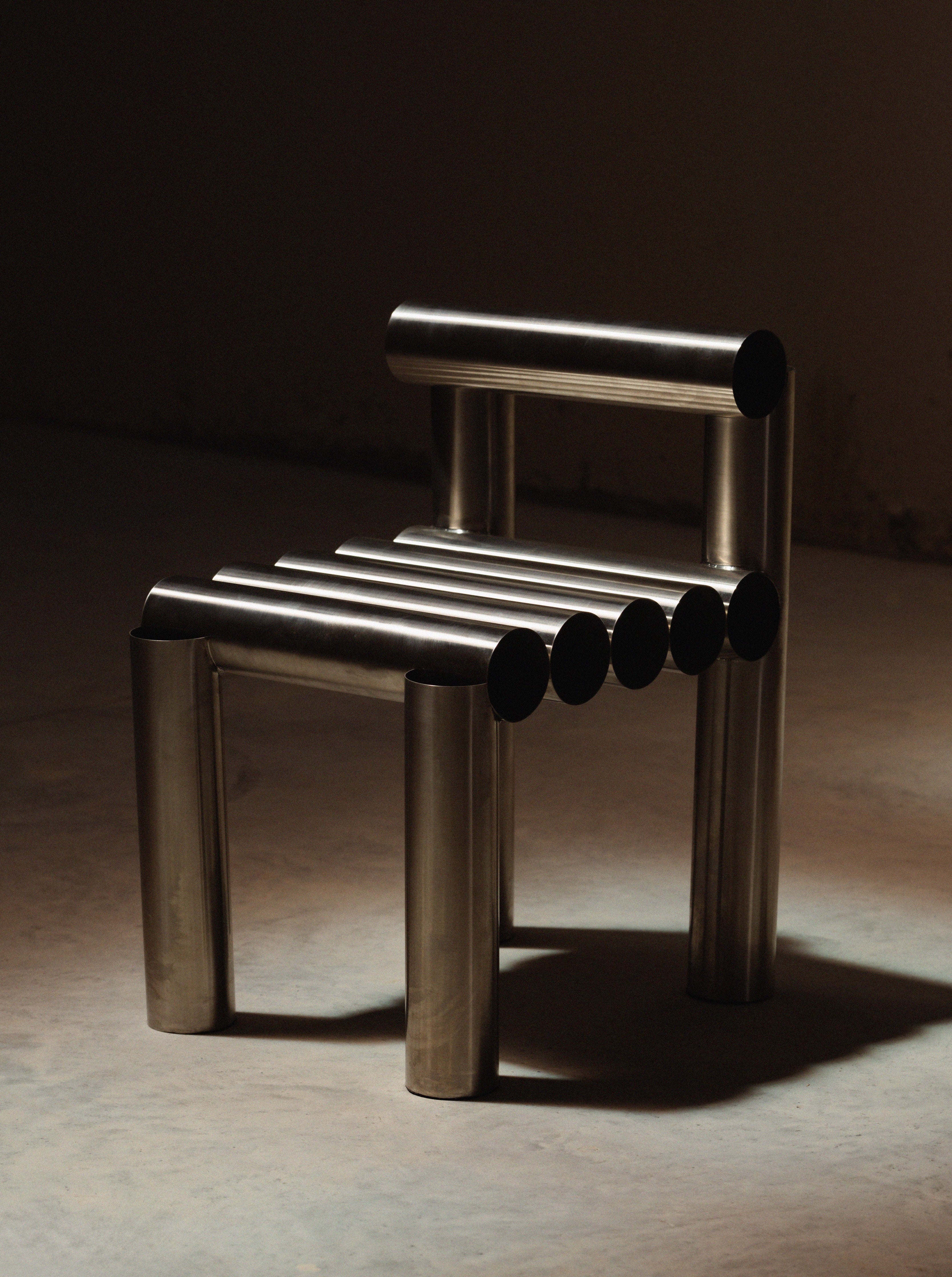 Modern metal chair with cylindrical design on a dark background