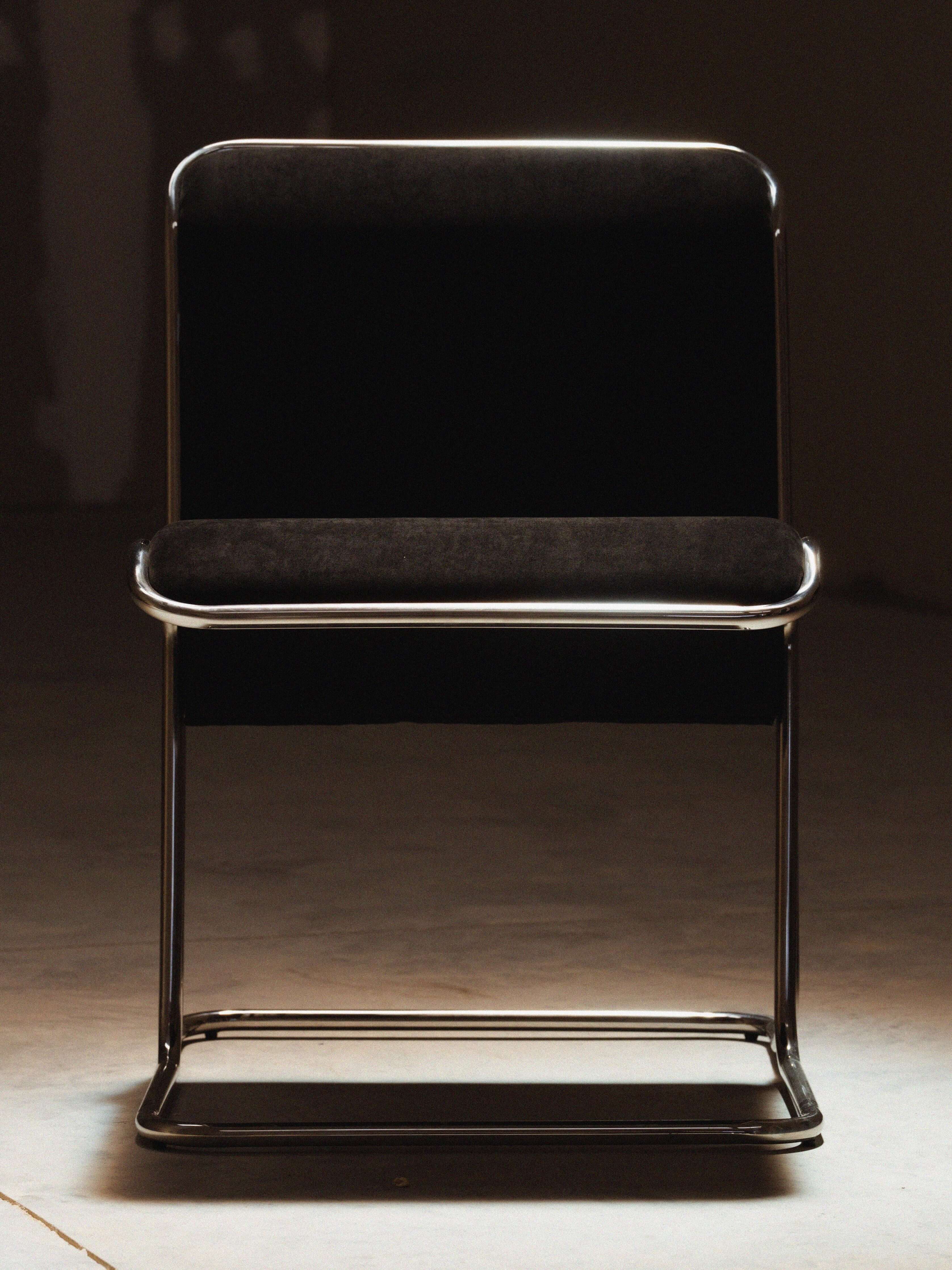 Calla Chair - Black chair with metal frame on a concrete floor