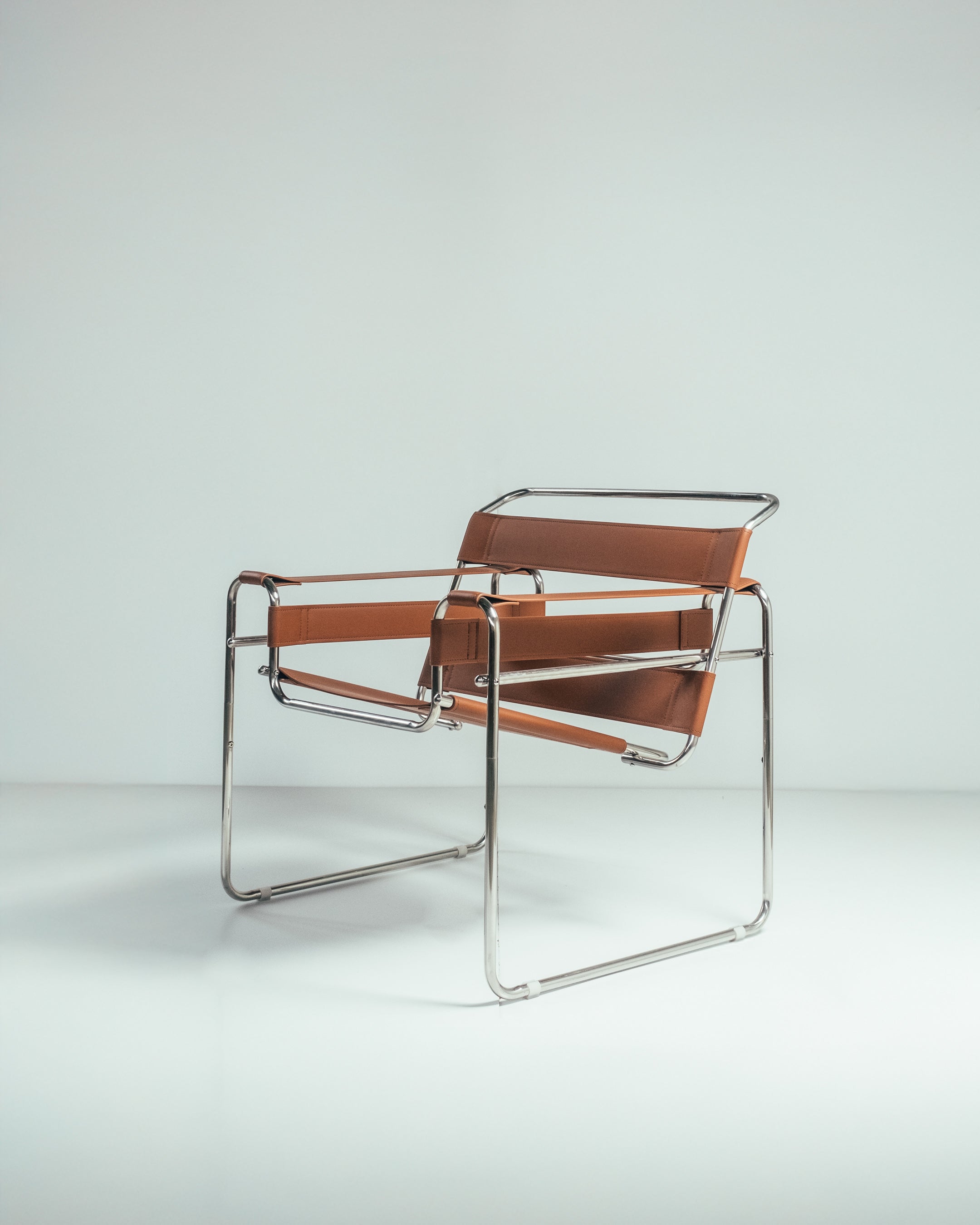 A Wassily chair with a chrome frame and brown leather seat, designed by Marcel Breuer.