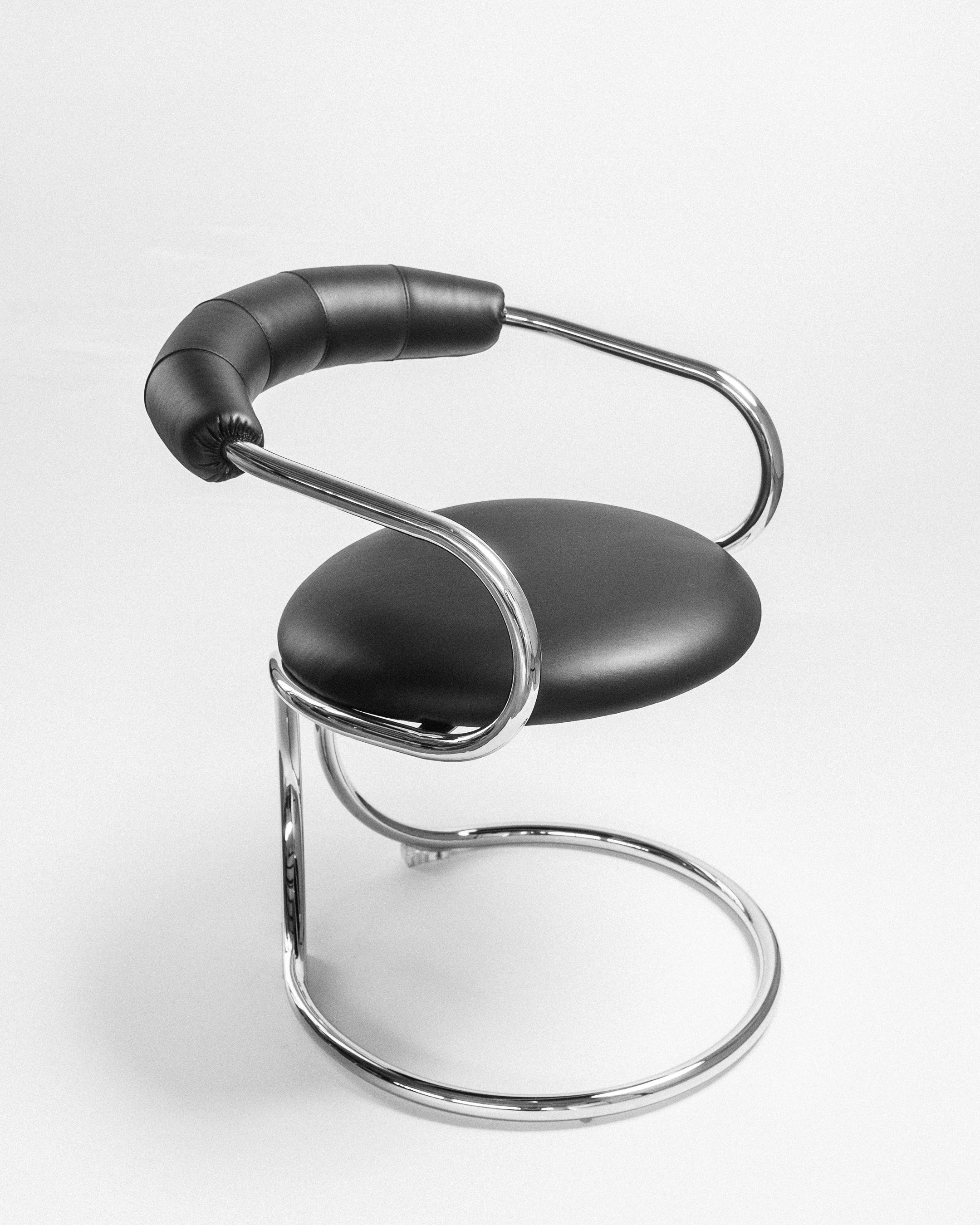 A black and silver metal chair with a unique design, featuring a circular seat and a handle.