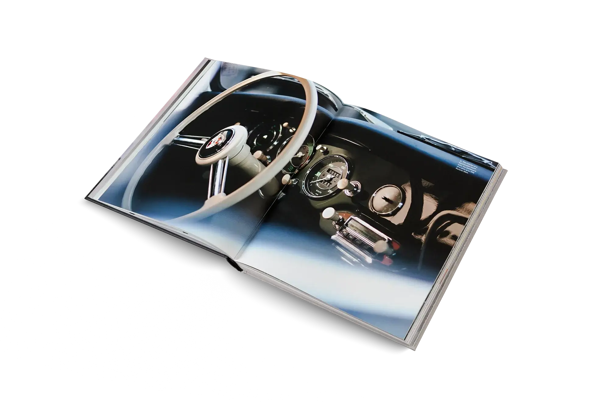 Open book showing a close-up of a car's steering wheel and dashboard on a white background