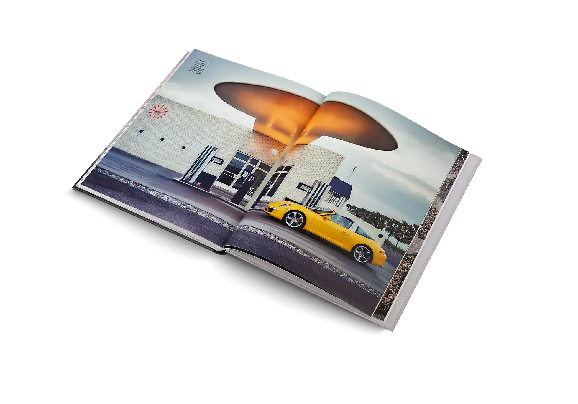 Open book showing a photograph of a yellow car in front of a building with a large orange object.