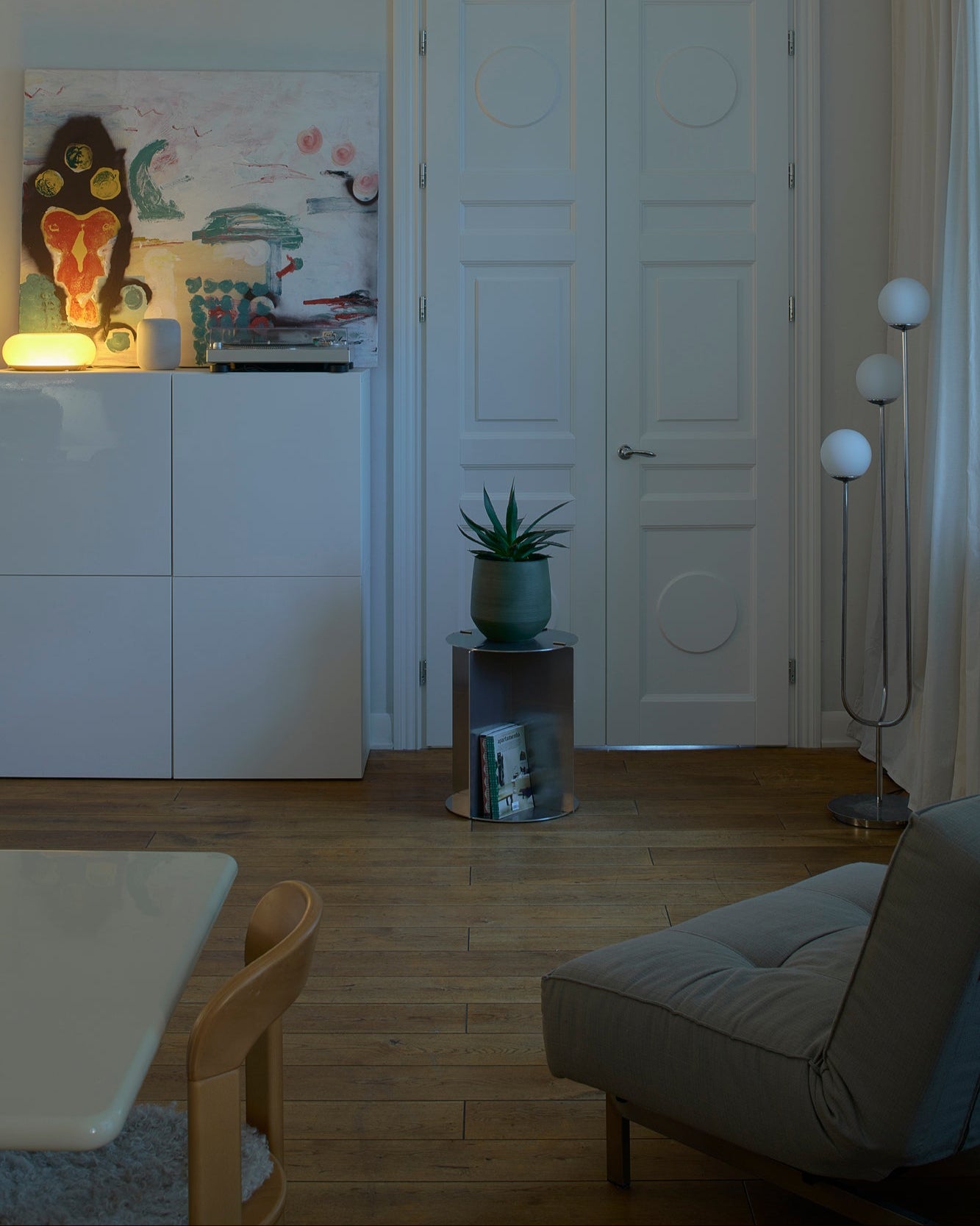 Living room with a white cabinet, plant, and gray sofa.