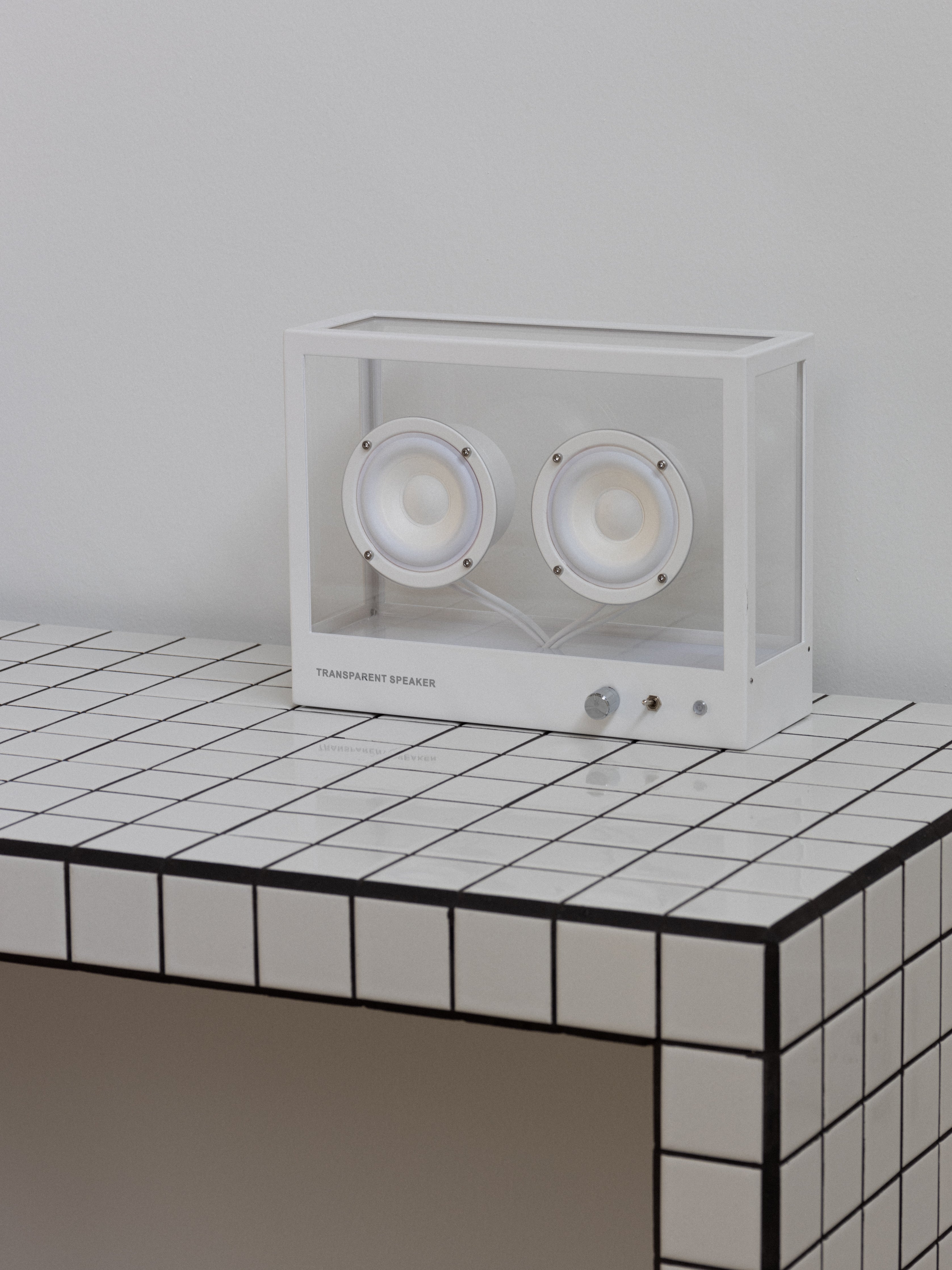 White electronic device with two circular components on a tiled surface