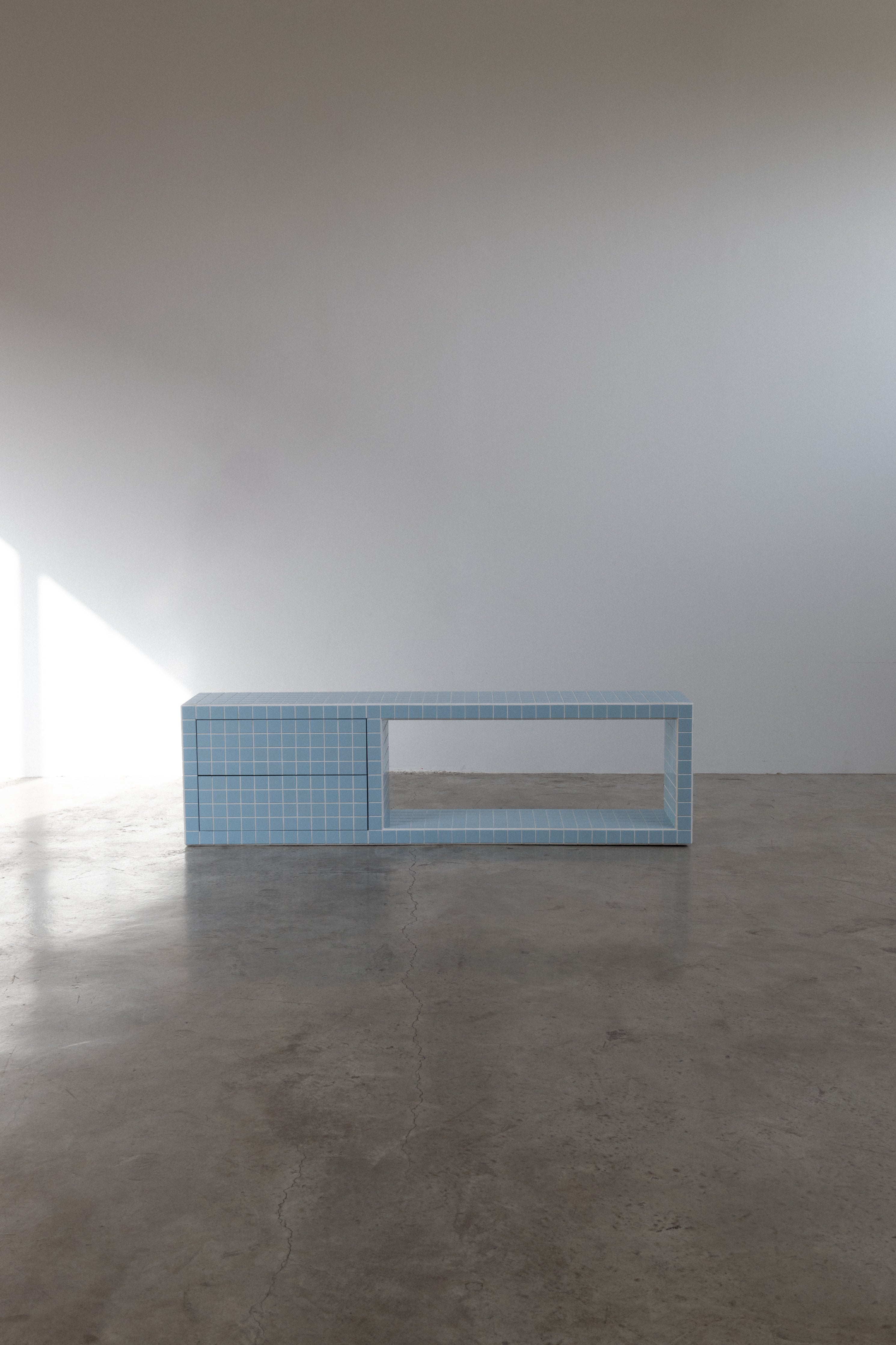 Blue tiled TV unit with open shelves and storage, modern design for stylish living spaces.