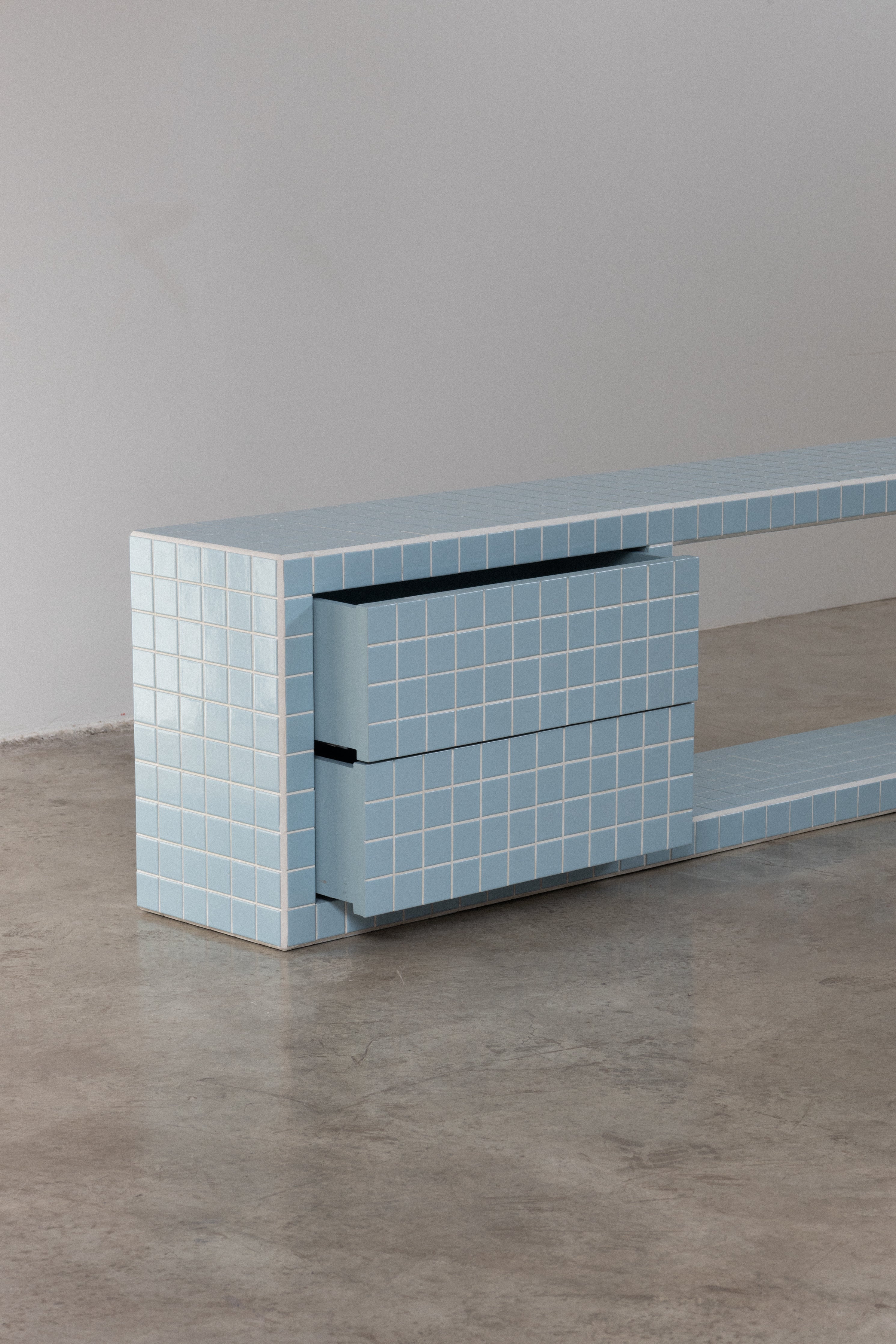 Tiled TV unit in soft blue with two drawers, featuring a modern and minimalist design.