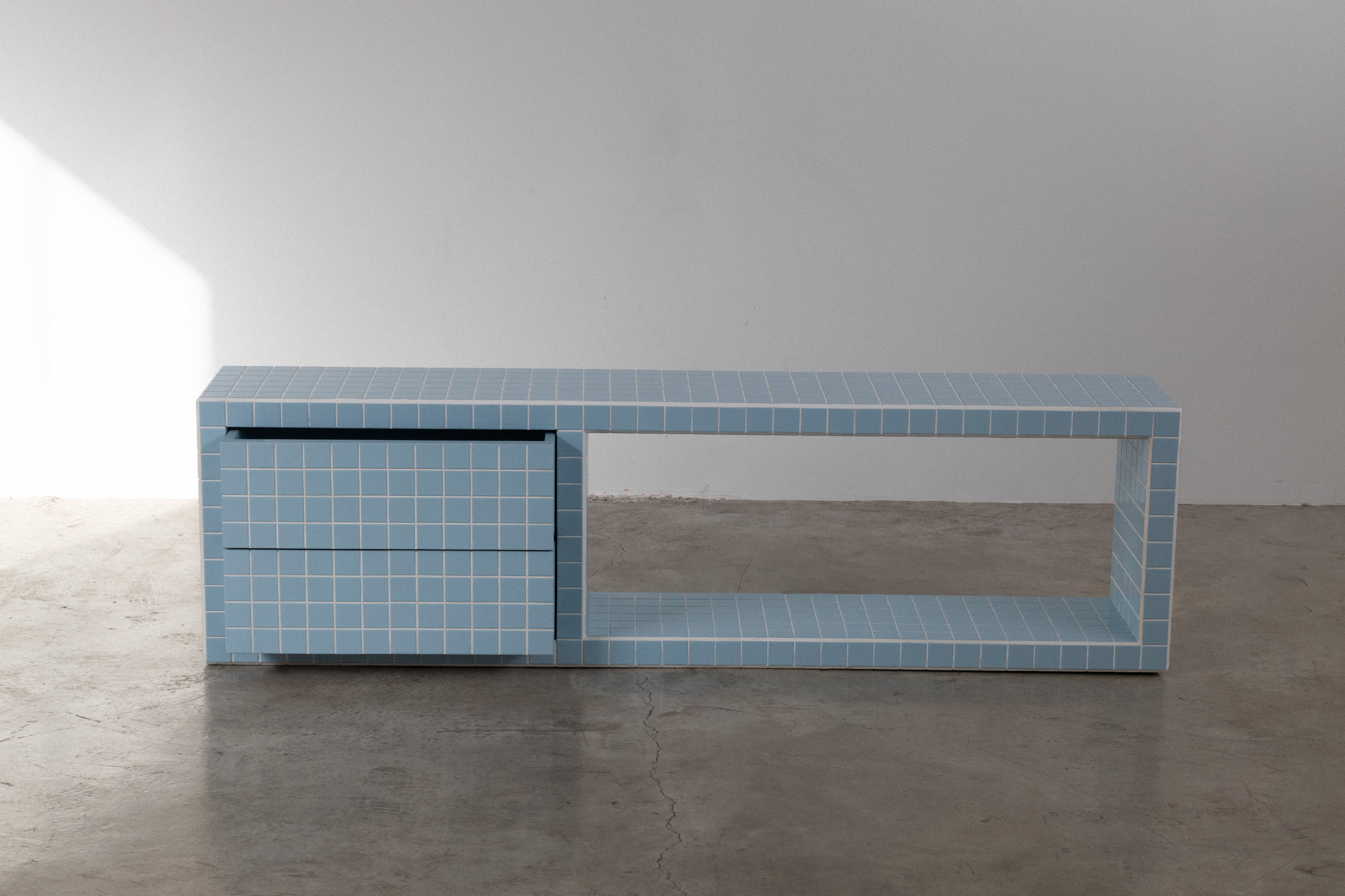 Modern tiled TV unit in blue with drawers and an open shelf, perfect for living room decor.