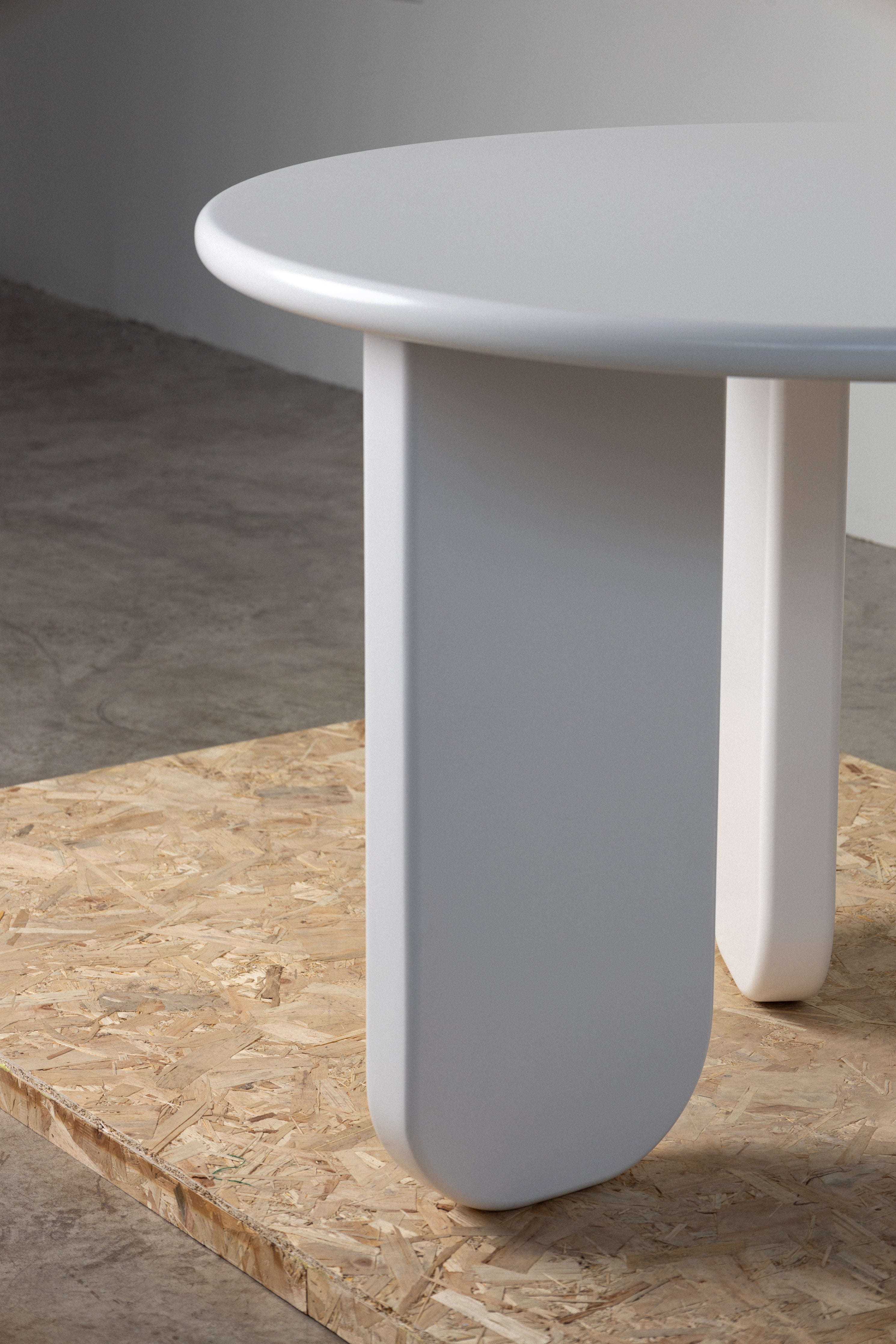 Contemporary Alara Dining Table – Elegant white dining table featuring a smooth round top and striking geometric base, perfect for modern dining spaces.