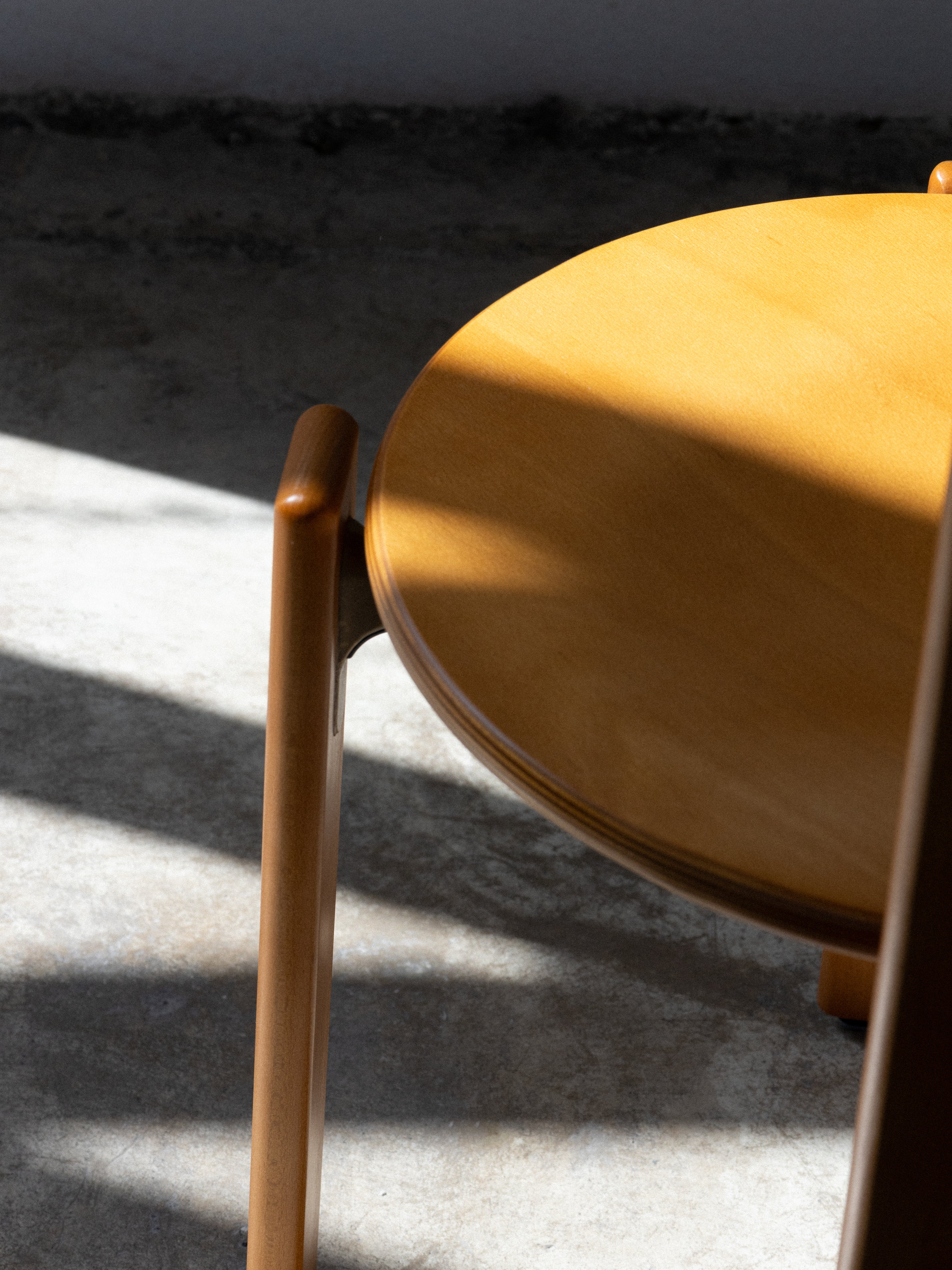 Close-up of a wooden chair with a blurred background. Rey Chair