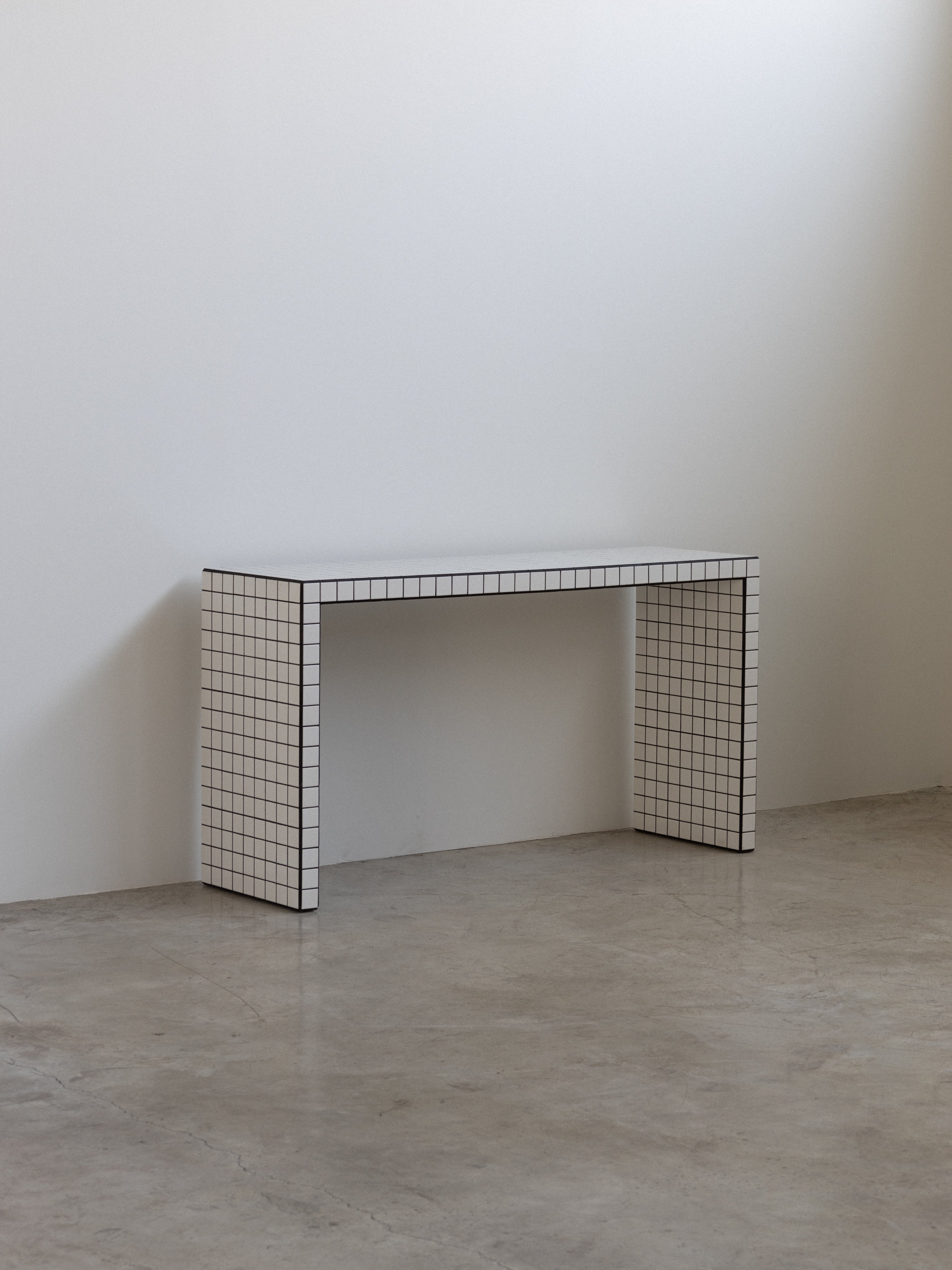 Minimalist table with grid pattern against a plain wall