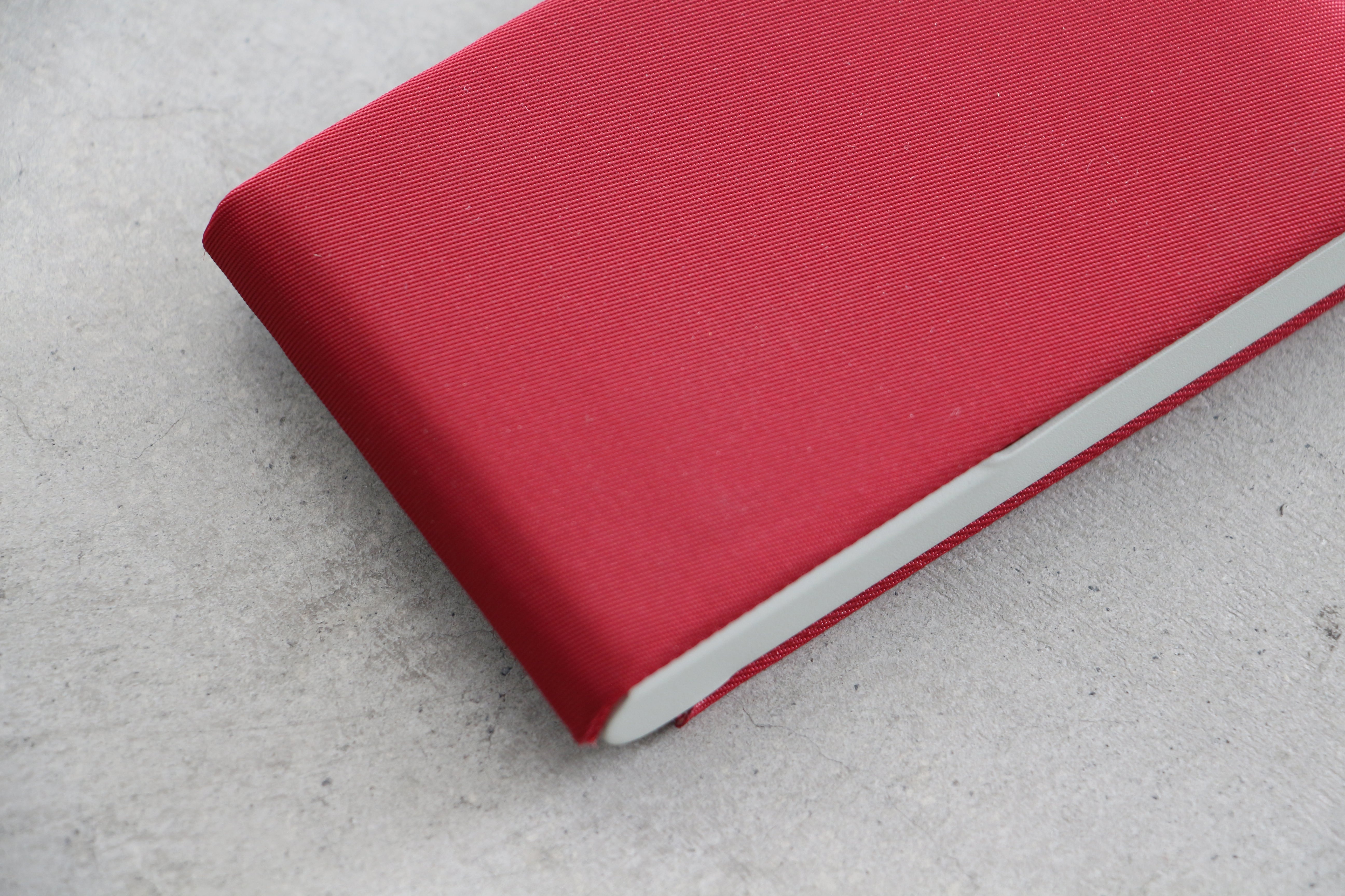 A red card case with a plain design and a visible zipper.